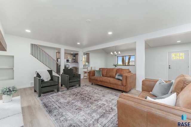 living room featuring light wood-type flooring and a chandelier