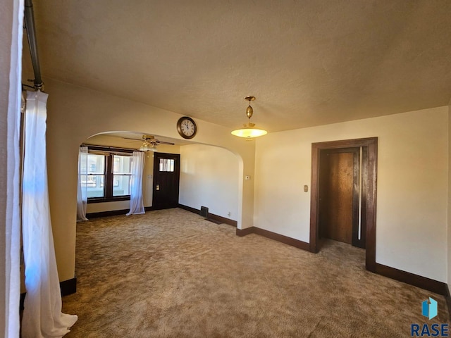 empty room with a textured ceiling, carpet flooring, and ceiling fan