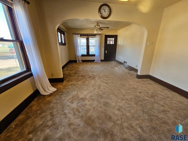 unfurnished room featuring dark colored carpet and ceiling fan