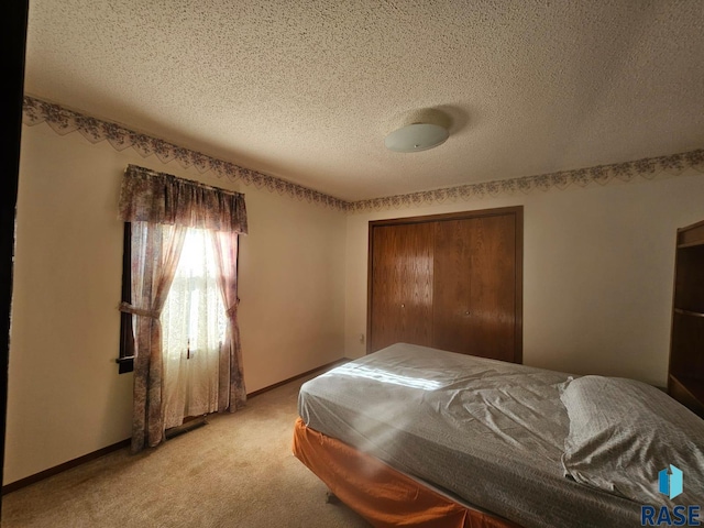 carpeted bedroom featuring a textured ceiling and a closet