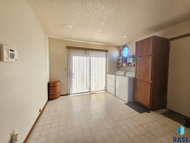 clothes washing area featuring washing machine and clothes dryer and a textured ceiling