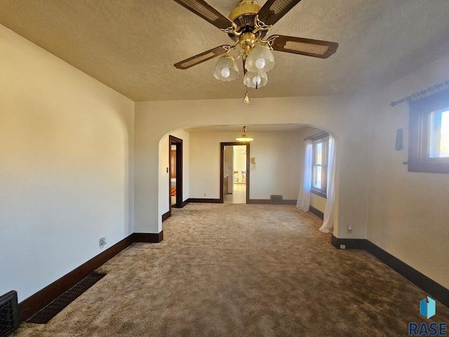 unfurnished room with a textured ceiling, ceiling fan, and carpet floors