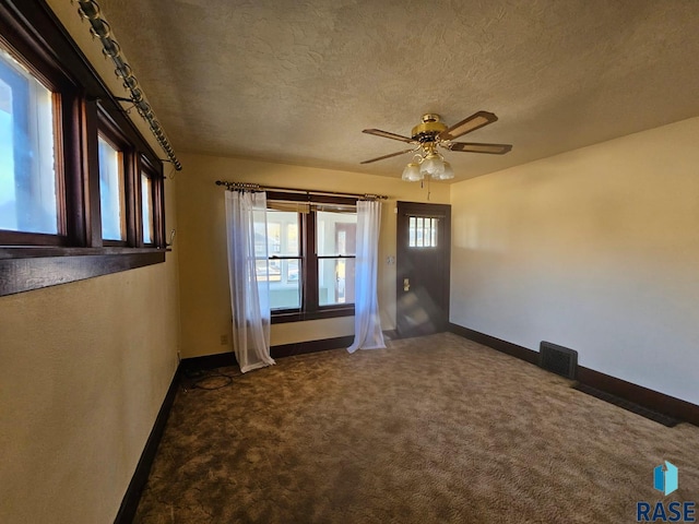 spare room featuring ceiling fan, a textured ceiling, and carpet floors