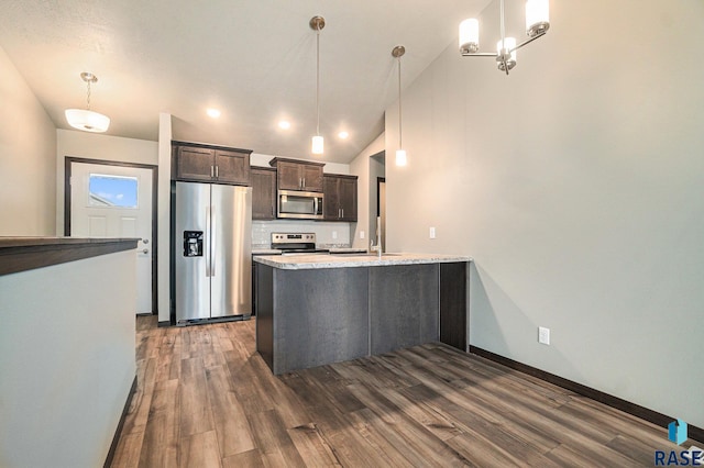 kitchen featuring stainless steel appliances, dark brown cabinets, pendant lighting, and dark hardwood / wood-style flooring