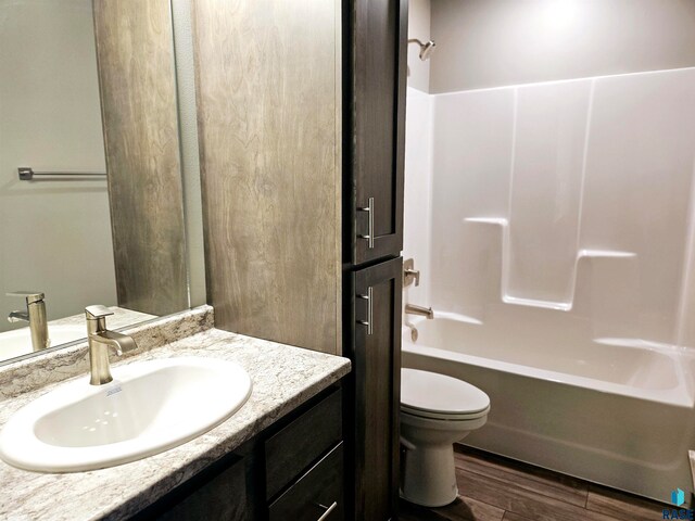 full bathroom featuring toilet, vanity, shower / bathtub combination, and hardwood / wood-style flooring