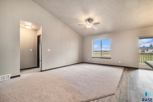 unfurnished room with ceiling fan, lofted ceiling, a textured ceiling, and light hardwood / wood-style floors