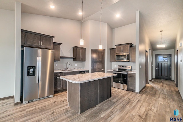 kitchen featuring dark brown cabinetry, stainless steel appliances, hanging light fixtures, and sink