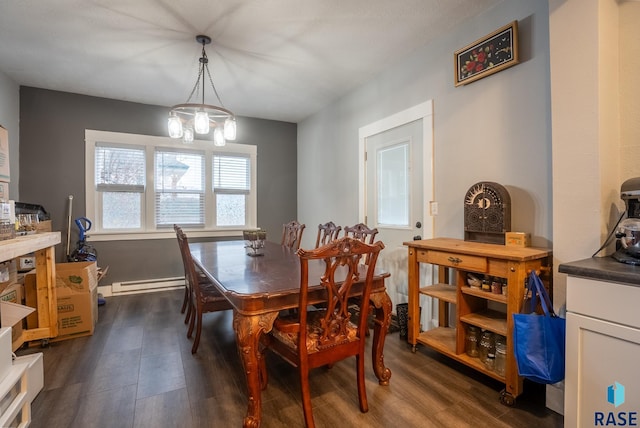 dining room featuring dark hardwood / wood-style flooring, a chandelier, and a baseboard heating unit