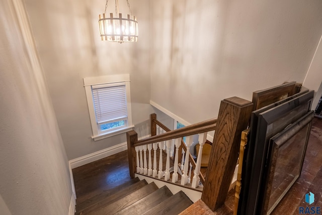 staircase featuring hardwood / wood-style floors and a chandelier