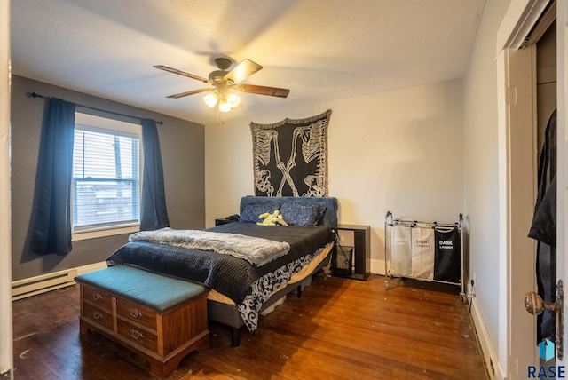 bedroom featuring ceiling fan, baseboard heating, and dark hardwood / wood-style flooring