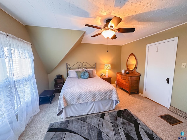 carpeted bedroom with ceiling fan and vaulted ceiling