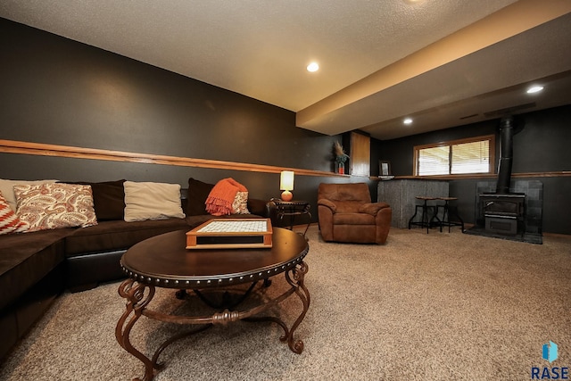 living room featuring a textured ceiling, a wood stove, vaulted ceiling, and carpet floors