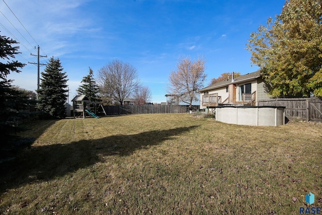 view of yard featuring a fenced in pool and a playground