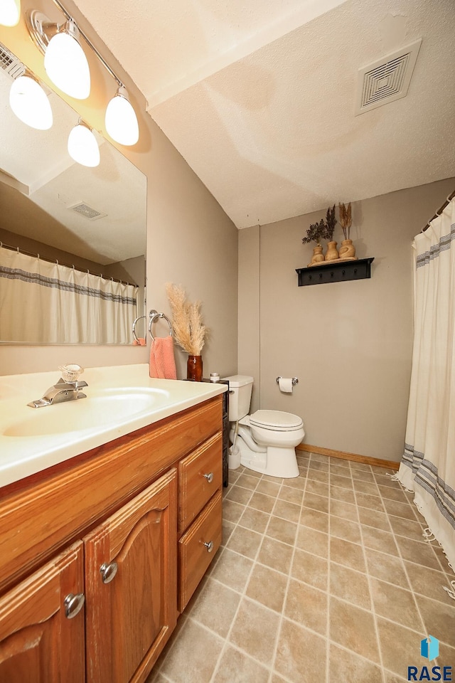 bathroom featuring vanity, a textured ceiling, and toilet