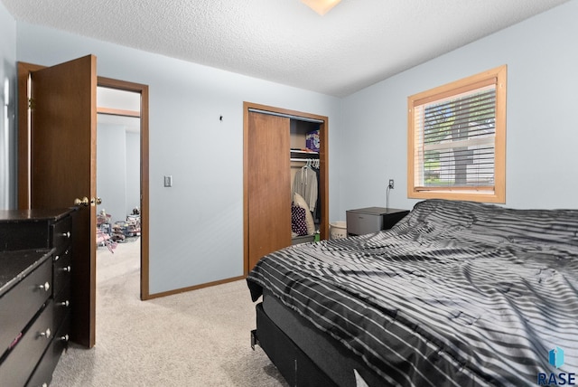 carpeted bedroom with a closet and a textured ceiling