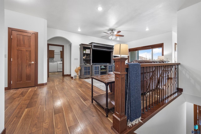 living room featuring ceiling fan, washer and dryer, and wood-type flooring