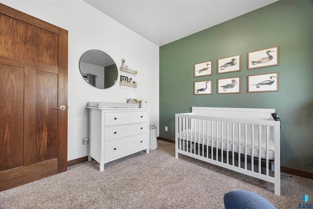 carpeted bedroom featuring a nursery area