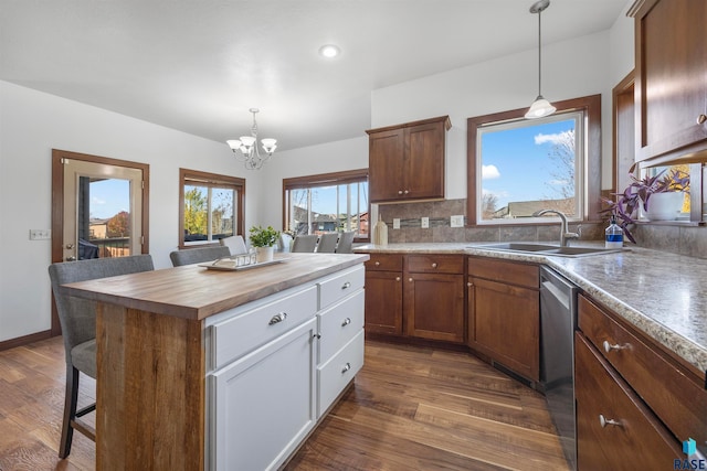 kitchen featuring an inviting chandelier, hanging light fixtures, sink, dark hardwood / wood-style floors, and a kitchen island