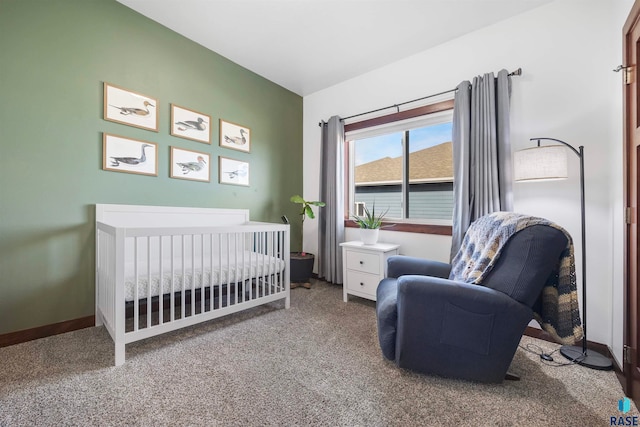 carpeted bedroom featuring a nursery area