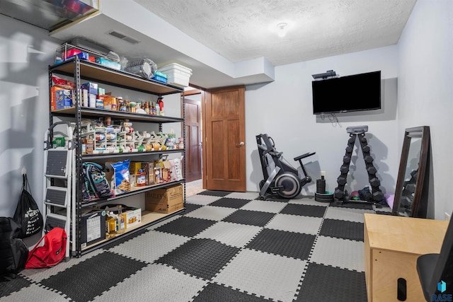 exercise room with a textured ceiling