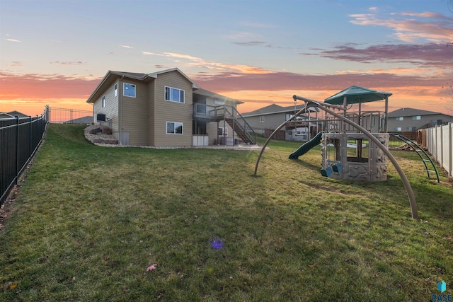 yard at dusk featuring a playground