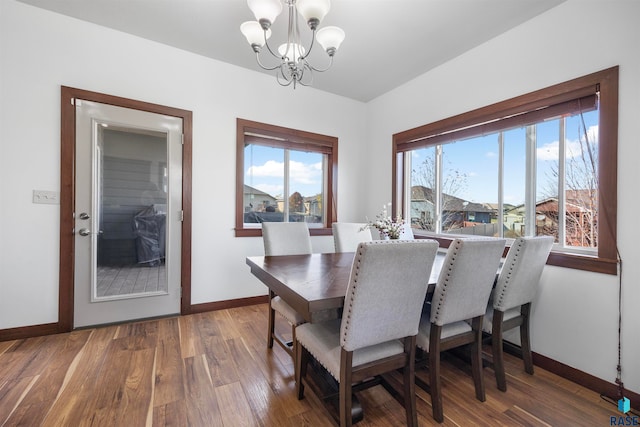 dining area featuring dark hardwood / wood-style floors and an inviting chandelier