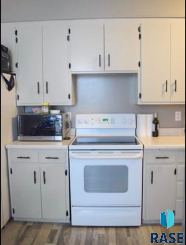 kitchen featuring white cabinets, hardwood / wood-style floors, and electric stove