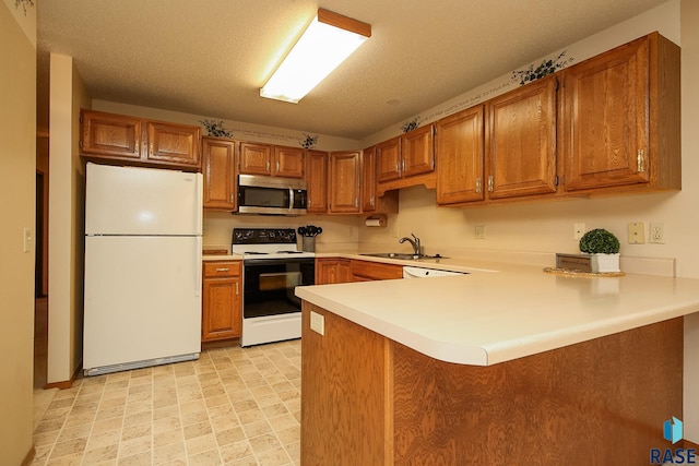 kitchen with kitchen peninsula, a textured ceiling, white appliances, and sink