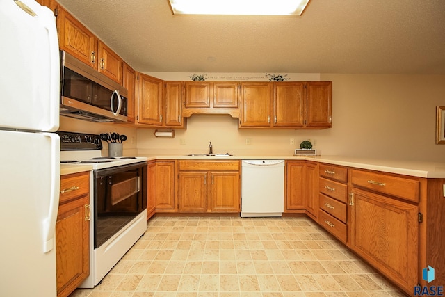 kitchen featuring white appliances, sink, and a textured ceiling