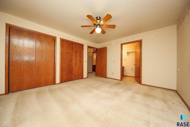 unfurnished bedroom featuring ceiling fan, light colored carpet, and a textured ceiling