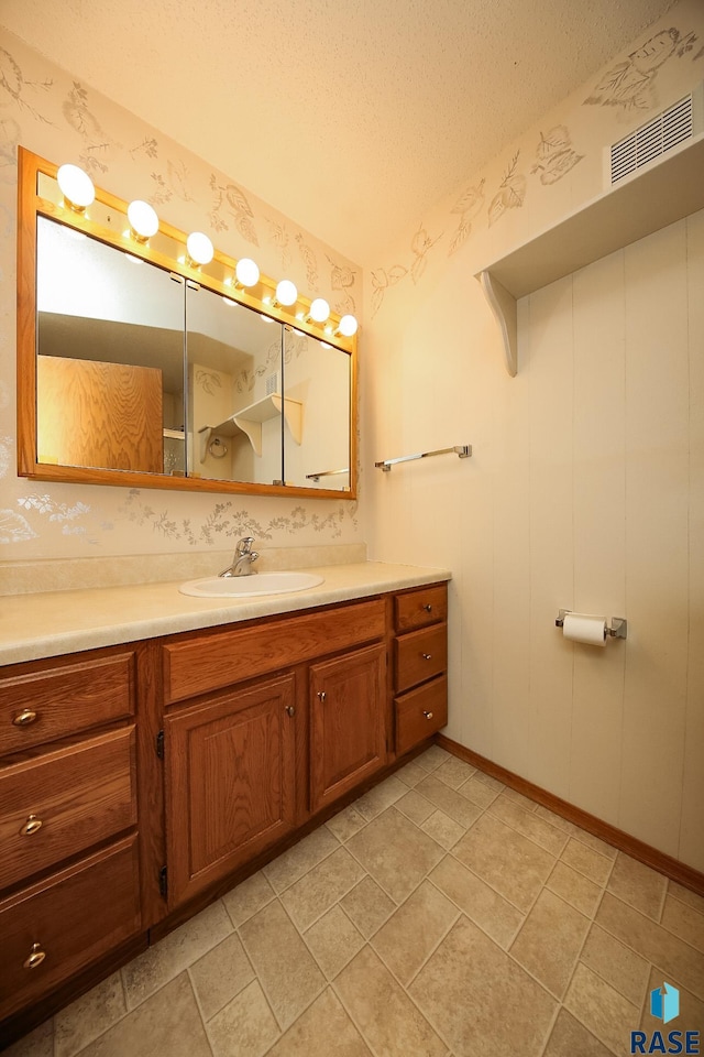 bathroom with vanity, tile patterned flooring, and a textured ceiling