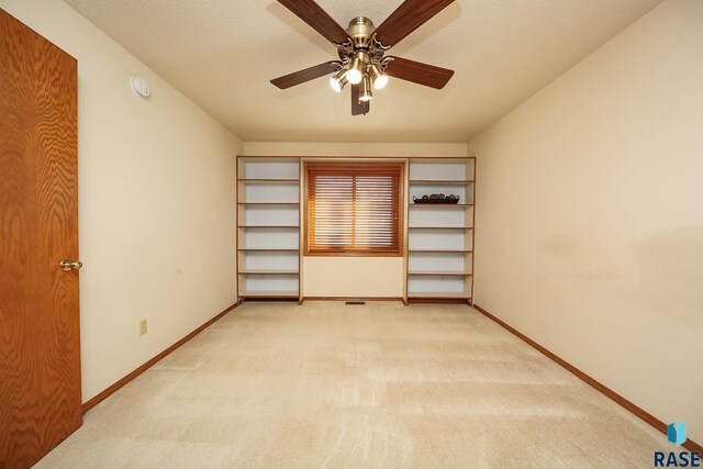 unfurnished bedroom featuring a closet, ceiling fan, light carpet, and a textured ceiling