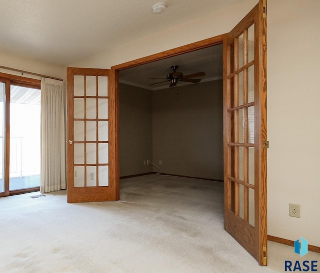 unfurnished room featuring carpet flooring, french doors, a textured ceiling, and ceiling fan