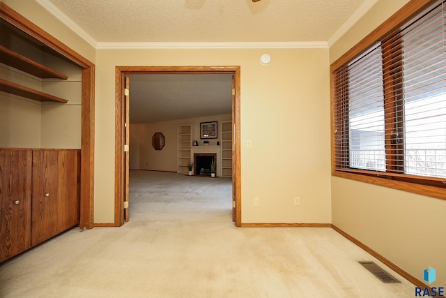 hall with ornamental molding, light carpet, and a textured ceiling