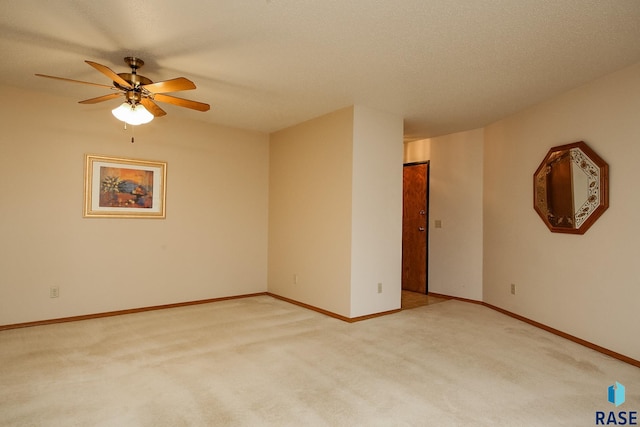 spare room with ceiling fan, light carpet, and a textured ceiling