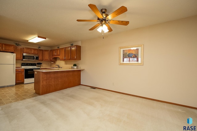 kitchen with kitchen peninsula, light carpet, white appliances, ceiling fan, and sink