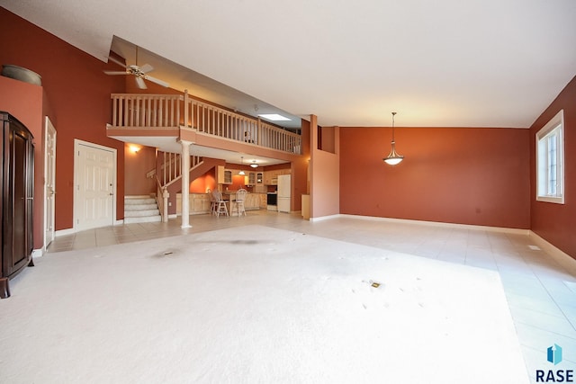 unfurnished living room featuring ceiling fan, light tile patterned floors, and high vaulted ceiling