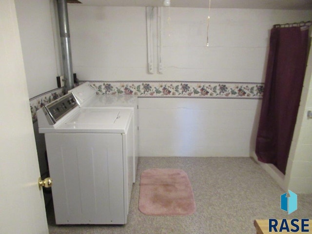 laundry room with tile walls and separate washer and dryer