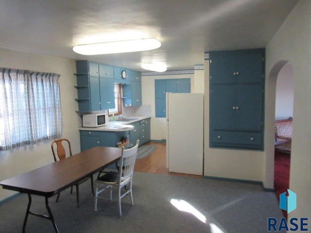 kitchen featuring blue cabinetry and white appliances