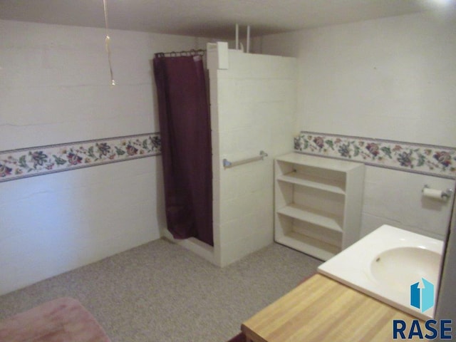 bathroom featuring vanity and tile walls