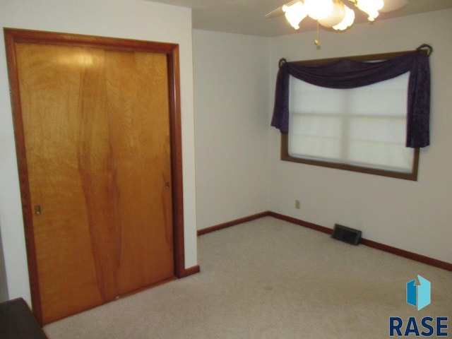 unfurnished bedroom with light colored carpet and ceiling fan