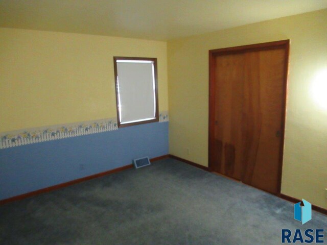 unfurnished bedroom with dark colored carpet