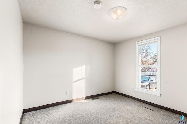 carpeted spare room with a textured ceiling