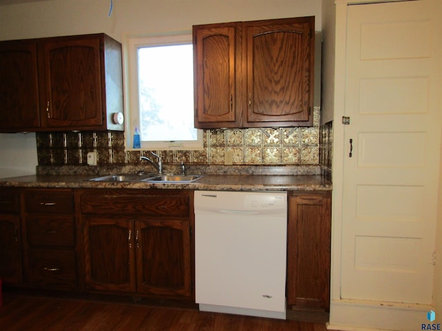 kitchen with dark wood-type flooring, tasteful backsplash, sink, and white dishwasher