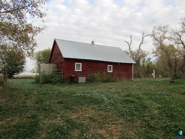 view of home's exterior featuring an outbuilding and a lawn