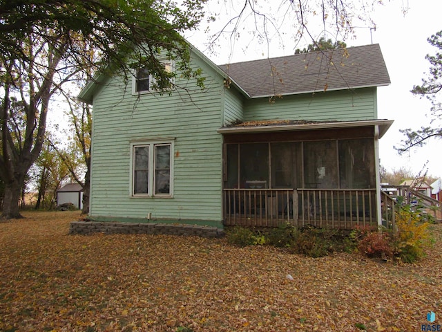 rear view of property featuring a sunroom