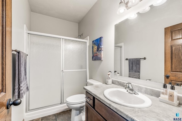 bathroom with vanity, a shower with shower door, tile patterned floors, and toilet