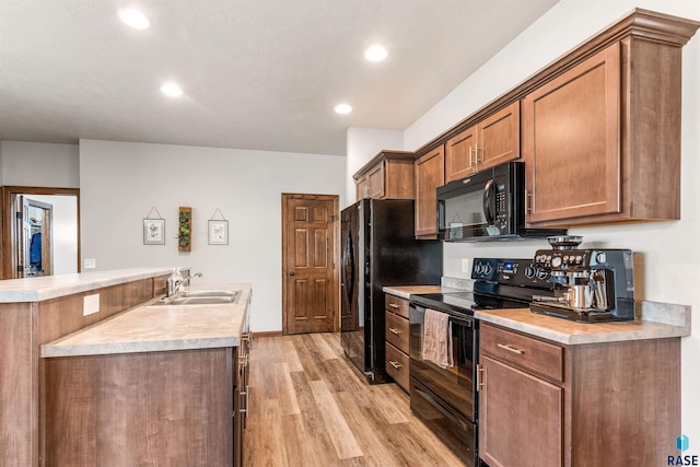 kitchen featuring light wood-type flooring, sink, and black appliances