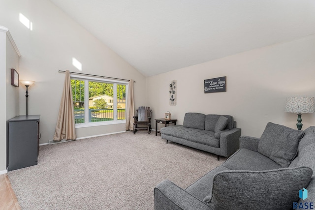 carpeted living room with high vaulted ceiling