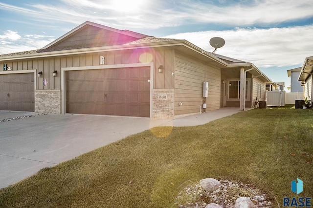 view of side of home with a lawn, a garage, and central AC